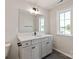 Bathroom featuring a large mirror, white counter, and window providing natural light at 4808 Glen Stripe Dr # Cal0036, Indian Trail, NC 28079