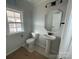 Well-lit half bathroom with pedestal sink, modern fixtures, and a window at 4808 Glen Stripe Dr # Cal0036, Indian Trail, NC 28079