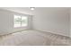 An empty bedroom with a large window, neutral walls and carpet flooring at 4808 Glen Stripe Dr # Cal0036, Indian Trail, NC 28079