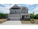 Inviting two-story home featuring a spacious two-car garage, stone accents, and a welcoming front porch at 4808 Glen Stripe Dr # Cal0036, Indian Trail, NC 28079