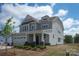 Charming two-story home showcasing meticulous landscaping, stone accents, and a covered front porch at 4808 Glen Stripe Dr # Cal0036, Indian Trail, NC 28079
