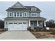 Charming two-story home featuring a spacious two car garage, covered porch, and beautiful light green siding at 4808 Glen Stripe Dr # Cal0036, Indian Trail, NC 28079