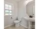 Stylish half-bath features a pedestal sink, modern fixtures, and a window providing natural light at 4808 Glen Stripe Dr # Cal0036, Indian Trail, NC 28079