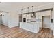 Open-concept kitchen with white cabinets, large island, stainless steel appliances, and wood-look flooring at 4808 Glen Stripe Dr # Cal0036, Indian Trail, NC 28079