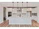 Open-concept kitchen featuring a center island, white cabinetry, stainless steel appliances, and hardwood flooring at 4808 Glen Stripe Dr # Cal0036, Indian Trail, NC 28079