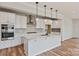 Modern kitchen featuring a large island, white cabinets, stainless steel appliances, and stylish pendant lighting at 4808 Glen Stripe Dr # Cal0036, Indian Trail, NC 28079