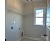 Bright laundry room features convenient shelving and natural light from a well-placed window at 4808 Glen Stripe Dr # Cal0036, Indian Trail, NC 28079