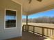 Covered porch with wood decking, railing, and a view of the undeveloped backyard at 4808 Glen Stripe Dr # Cal0036, Indian Trail, NC 28079