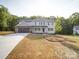 Well-manicured front yard leading to a charming two-story home with a two-car garage and blue siding at 1133 Heather Oak Ln, Oakboro, NC 28129