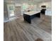 Bright kitchen featuring an island with countertop, white cabinets, stainless appliances, and wood-look flooring at 1133 Heather Oak Ln, Oakboro, NC 28129