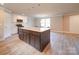 Open-concept kitchen featuring a large island, white cabinets, and modern appliances at 1133 Heather Oak Ln, Oakboro, NC 28129