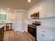 Modern kitchen with stainless steel appliances, white cabinets, quartz countertops, and herringbone backsplash, offering a sleek design at 1133 Heather Oak Ln, Oakboro, NC 28129