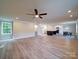 Spacious open-concept living room with wood-look flooring and a ceiling fan, flowing into the kitchen at 1133 Heather Oak Ln, Oakboro, NC 28129