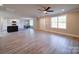 Open-concept living space with wood-look flooring connecting the living room, dining area, and kitchen at 1133 Heather Oak Ln, Oakboro, NC 28129