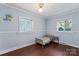 A charming blue bedroom with hardwood floors and lots of natural light from two windows at 209 21St St, Newton, NC 28658
