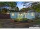 Charming single-story home featuring light blue siding, well-manicured landscaping, and welcoming front entrance at 209 21St St, Newton, NC 28658