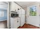 Efficient kitchen area with microwave, refrigerator, white cabinets and convenient access to the outside at 209 21St St, Newton, NC 28658