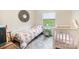 Bright bedroom featuring a single bed, a crib and a window with a view of green fields at 1007 Ashford St, Charlotte, NC 28214