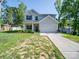 Two-story home with attached garage and well-manicured front lawn and side storage shed at 8932 Myra Way, Charlotte, NC 28215