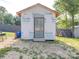 Exterior view of the backyard shed, featuring a metal door and front steps at 8932 Myra Way, Charlotte, NC 28215