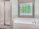 The bathroom has a garden tub with window and separate shower with glass door at 423 Old Dutch Rd, Indian Trail, NC 28079