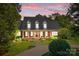 Brick home with a classic design and landscaping at dusk at 721 Orphanage Rd, Concord, NC 28027