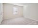 Well-lit bedroom featuring gray carpeting and a window with blinds at 1610 Cannonball Ln, Bessemer City, NC 28016