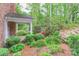 Brick patio featuring lush landscaping, a covered porch, flowering azaleas, and a mulched garden at 715 Saint Cloud Dr, Statesville, NC 28625