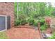 Brick patio surrounded by manicured landscaping, flowering azaleas, and mature trees with a view of the yard at 715 Saint Cloud Dr, Statesville, NC 28625