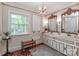 Luxurious bathroom featuring a double vanity, decorative mirrors, a chandelier, and a large window providing ample natural light at 715 Saint Cloud Dr, Statesville, NC 28625