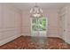 Elegant dining room with wainscoting, chandelier, and access to outdoor patio at 715 Saint Cloud Dr, Statesville, NC 28625