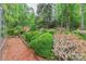 Beautifully landscaped garden with brick pathway, flowering bushes, mature trees and greenery creating a serene, inviting outdoor space at 715 Saint Cloud Dr, Statesville, NC 28625