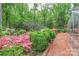 Well-manicured gardens with lush greenery, a brick pathway, bridge, and a variety of flowering plants, creating a tranquil outdoor space at 715 Saint Cloud Dr, Statesville, NC 28625