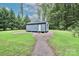 New shed with classic architectural design, nestled in a lush green yard with a natural, wooded backdrop at 715 Saint Cloud Dr, Statesville, NC 28625