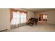 Bright living room with plush carpeting, a piano, and decorative window treatments at 370 21St Nw Ave, Hickory, NC 28601