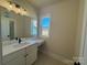 Bright bathroom with a vanity area, featuring white cabinetry, a makeup counter, and a window at 4379 Morning Mist Dr # 12, Sherrills Ford, NC 28673