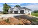 New construction home featuring a white exterior, stone accents, and a spacious three-car garage at 117 Hatford Ct, Statesville, NC 28625