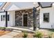 Charming front porch featuring stone accents, a dark-stained front door, and manicured landscaping at 117 Hatford Ct, Statesville, NC 28625