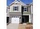 Two-story townhome with gray and green siding, white garage door, and landscaping at 4061 Lawnview Dr, Charlotte, NC 28269