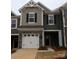 Two-story townhome with gray siding, stone accents, and a two-car garage at 4061 Lawnview Dr, Charlotte, NC 28269