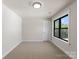 An empty bedroom with neutral walls and carpet offers plenty of natural light and closet space at 171 Heartland Dr # 7, Rock Hill, SC 29732