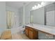 Bright bathroom featuring a shower-tub combo, a toilet, and an extended vanity at 9341 Lenox Pointe Dr, Charlotte, NC 28273