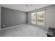 Serene bedroom with neutral paint, plush carpeting, and a large window for ample natural light at 9341 Lenox Pointe Dr, Charlotte, NC 28273