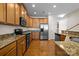 Well-equipped kitchen featuring stainless steel appliances, granite counters, and warm wood cabinetry at 9341 Lenox Pointe Dr, Charlotte, NC 28273