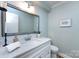 Bright bathroom features a framed mirror, white marble countertop, and tiled flooring at 430 Queens Rd # 712, Charlotte, NC 28207