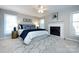 Well-lit main bedroom featuring a cozy fireplace, a ceiling fan, and stylish decor at 430 Queens Rd # 712, Charlotte, NC 28207