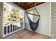 Tranquil covered porch featuring a hanging hammock chair and views of the surrounding trees at 430 Queens Rd # 712, Charlotte, NC 28207