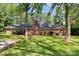 House back view, showcasing brick facade and large yard at 1801 Windsor Dr, Lancaster, SC 29720