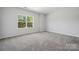 Bedroom with neutral carpeting and paint, featuring a large window that provides lots of natural light at 133 Jentri Way, Mooresville, NC 28115