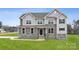 Stunning two-story home featuring a stone facade, gray siding, multiple windows, and a well-manicured lawn at 133 Jentri Way, Mooresville, NC 28115